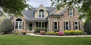 A charming suburban home stands among lush landscaping, radiating a warm and welcoming atmosphere.